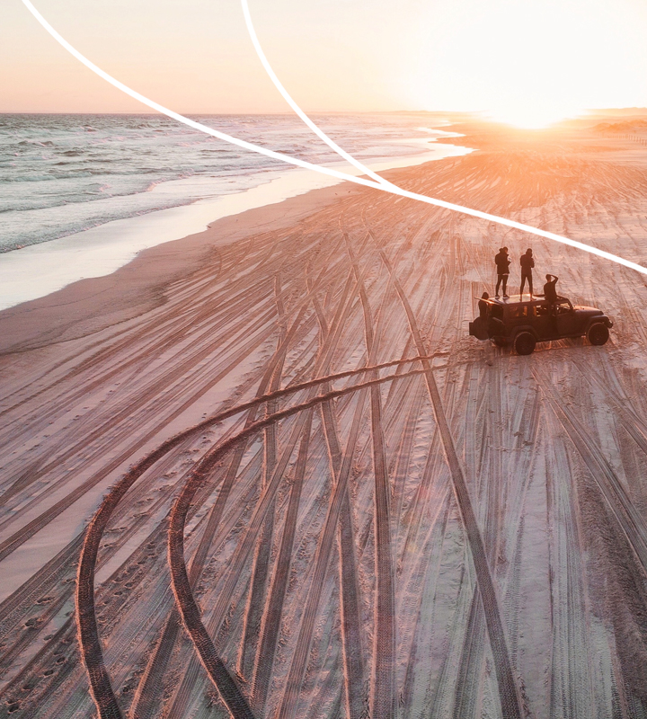 coast-insurance_home_about_background - beach sunset 3 men standing on car